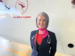 Cabin crew member standing in front of a plane, smiling