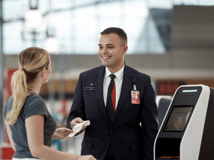 A customer service agent welcoming customers to the business class line