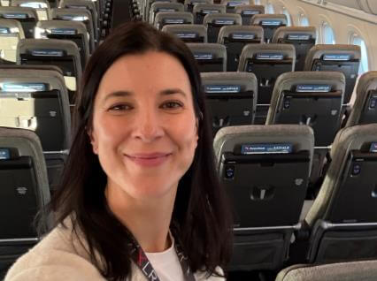 Qantas employee smiling at camera on board a Qantas aircraft