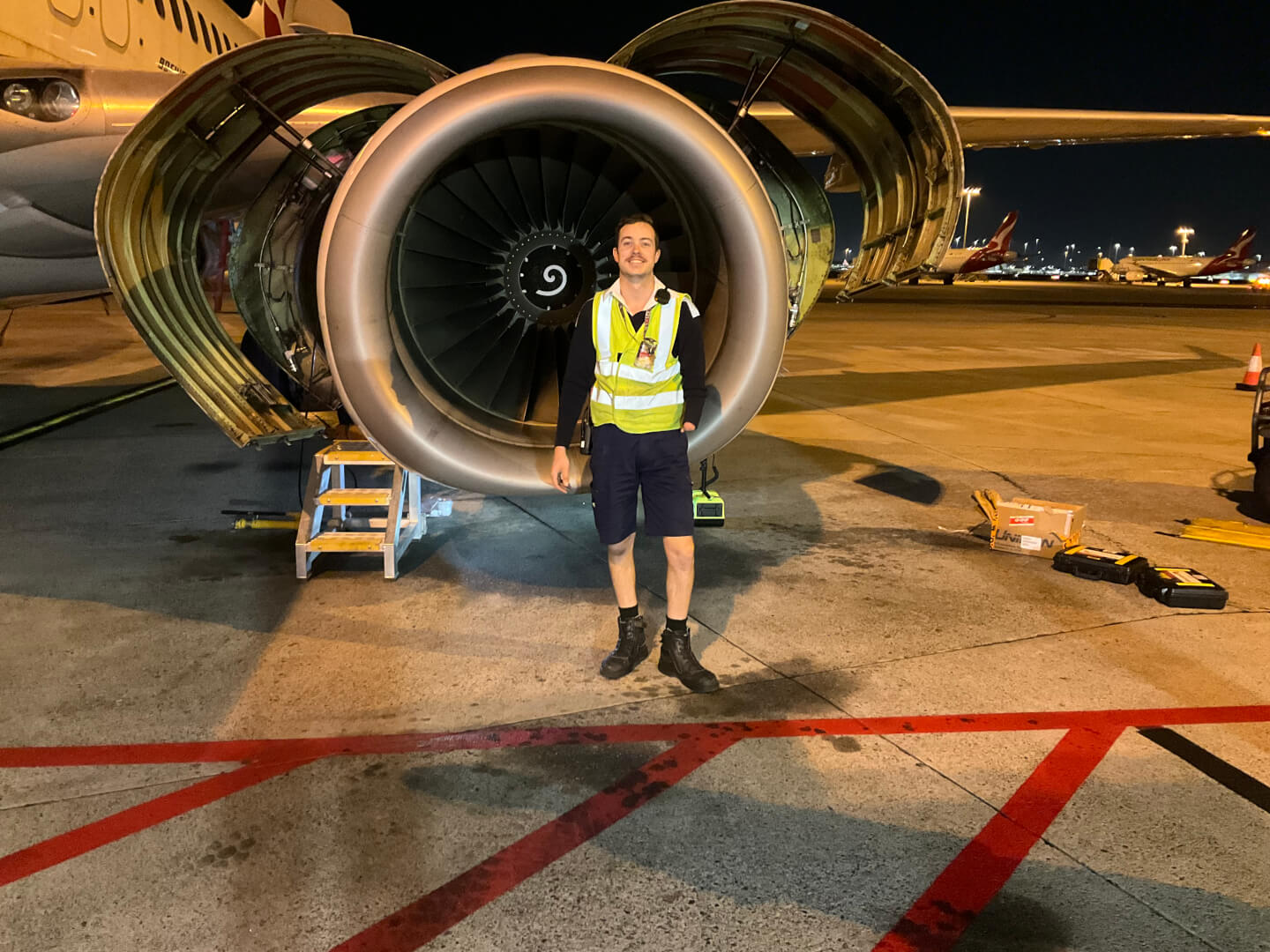 Qantas employee standing in front of plane  