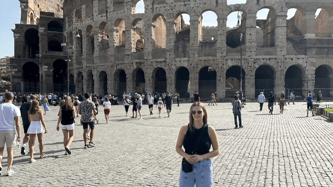 Girl standing in front of a colosseum in Rome