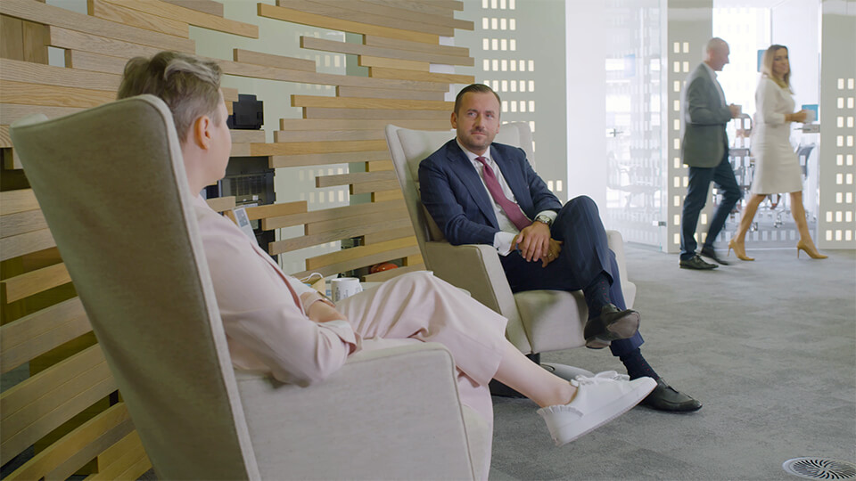 two colleagues having a conversation in a glass room