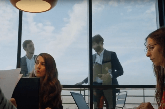 two colleagues having a conversation in a glass room