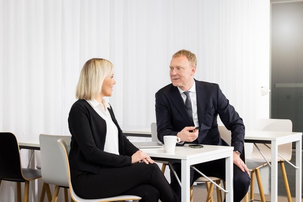 two colleagues having a conversation in a glass room