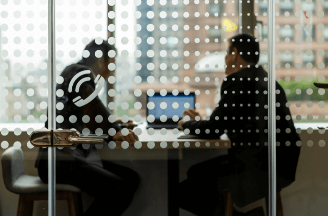 two colleagues having a conversation in a glass room