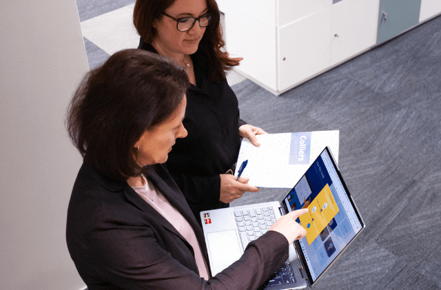 two colleagues having a conversation in a glass room