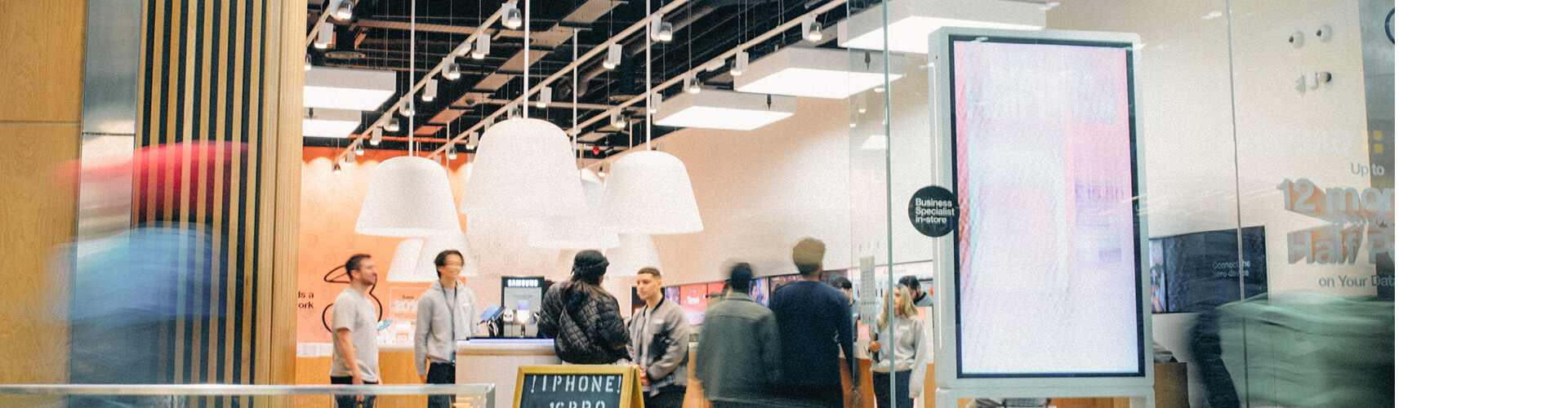 Front of a Three store with people walking past 