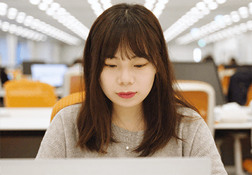 An image of a woman looking at a computer