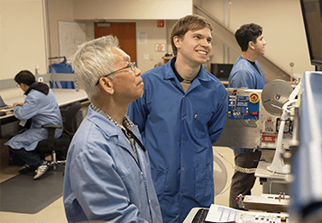 An image of two people looking at a screen while smiling 