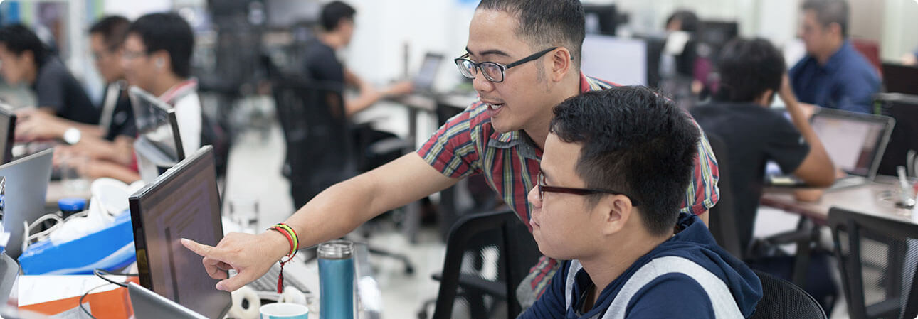 An image of two people looking at a computer 