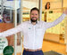A male Specsavers partner stands out the front of his store