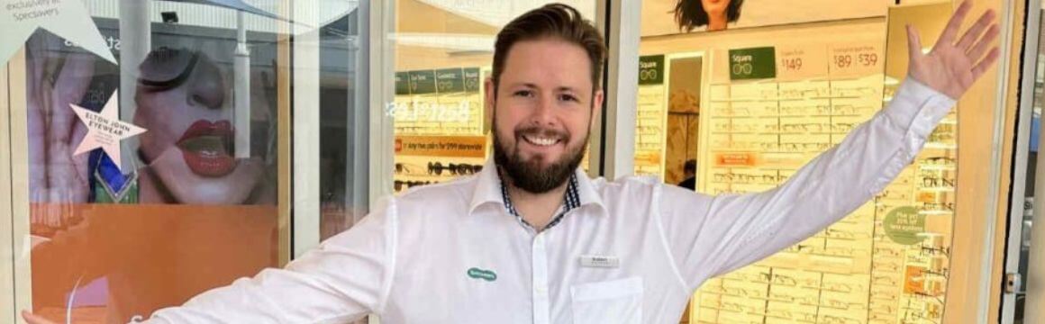 A male Specsavers partner stands out the front of his store