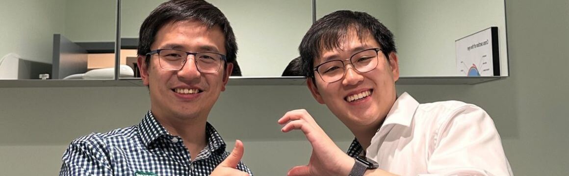 Two men stand in a optometry test room