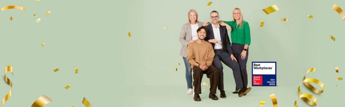 Group of people stand with confetti around them and best workplace badge