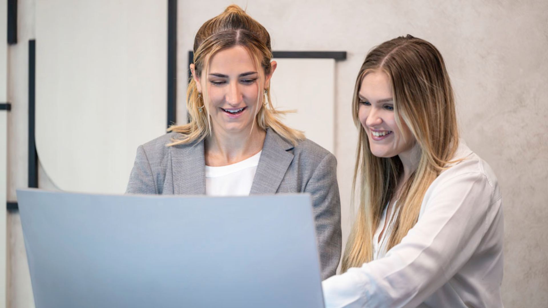 image of hotel receptionist looking at computer and smiling 