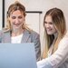 image of hotel receptionist looking at computer and smiling 