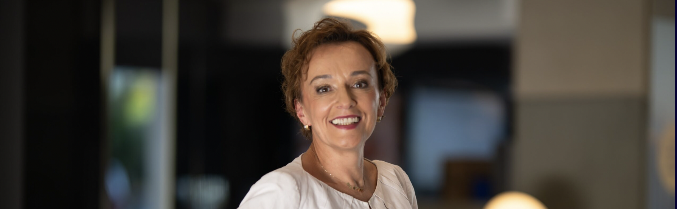 kristina - hotel general manager at Accor posing for a photo and smiling in white suit