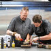 Two chefs preparing a dish in the kitchen.