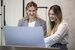 image of hotel receptionist looking at computer and smiling 