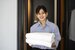 housekeeper with blue shirt holding towels and smiling 