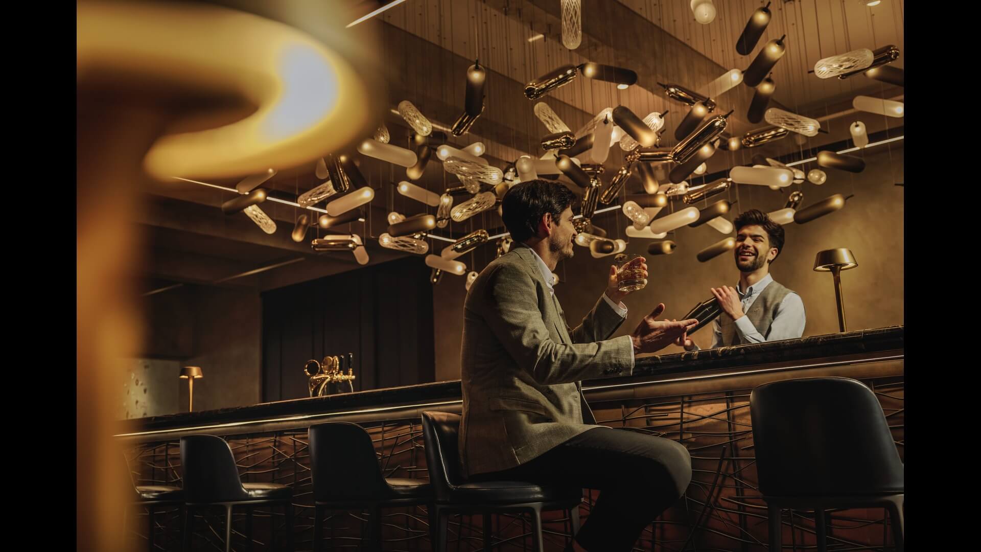 image of bartender and guest being served a drink