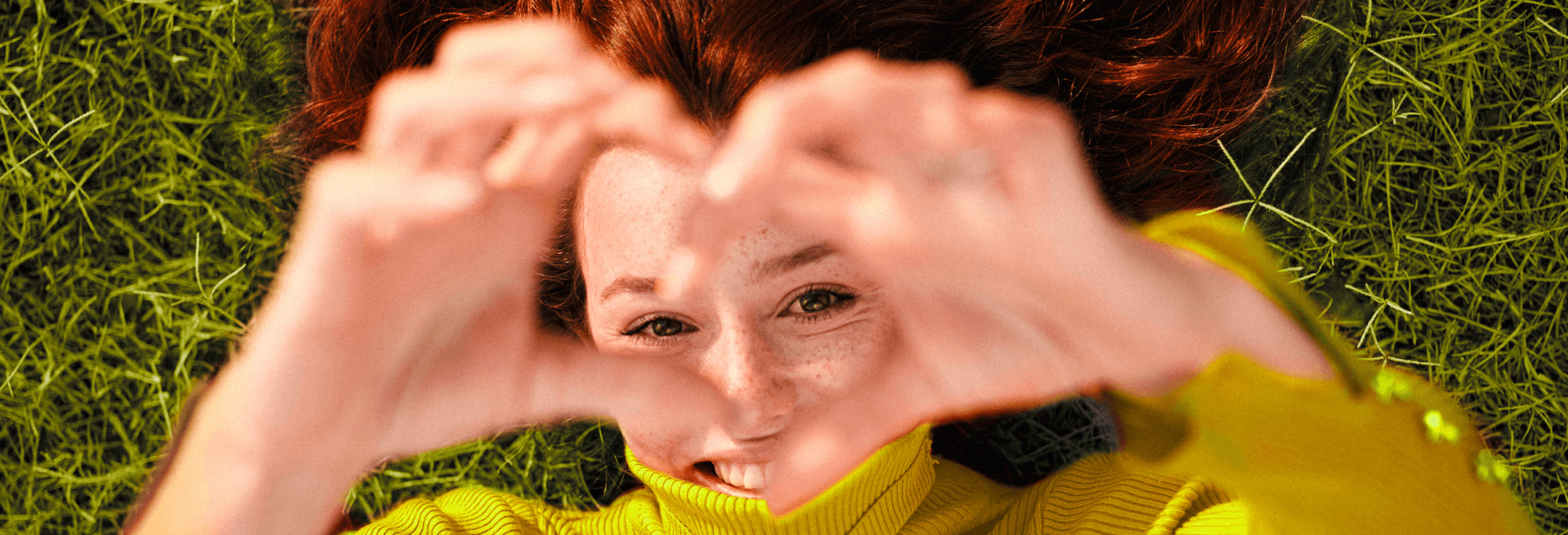 woman making heart shape with her hands and smiling