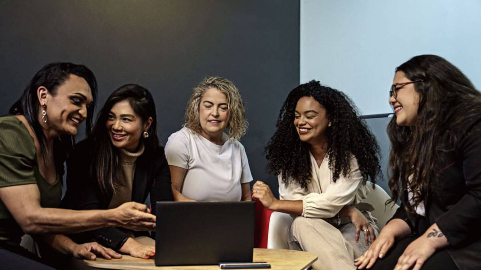 head office job at accor - people sitting around a table smiling with a laptop