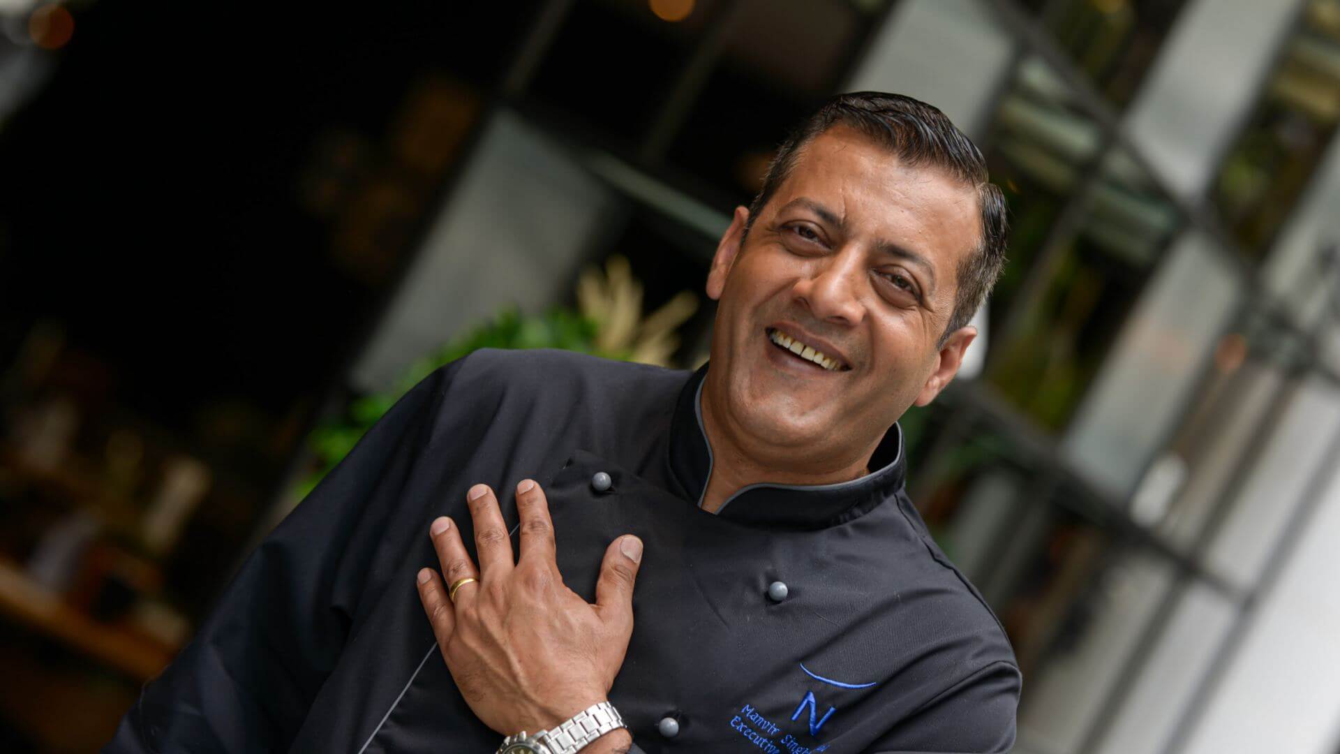 manvir singh- executive chef smiling with hand on heart