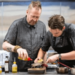 Two chefs preparing a dish in the kitchen.