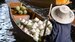 image of boat driver with coconuts wearing a thailand hat 