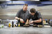 Two chefs preparing a dish in the kitchen.