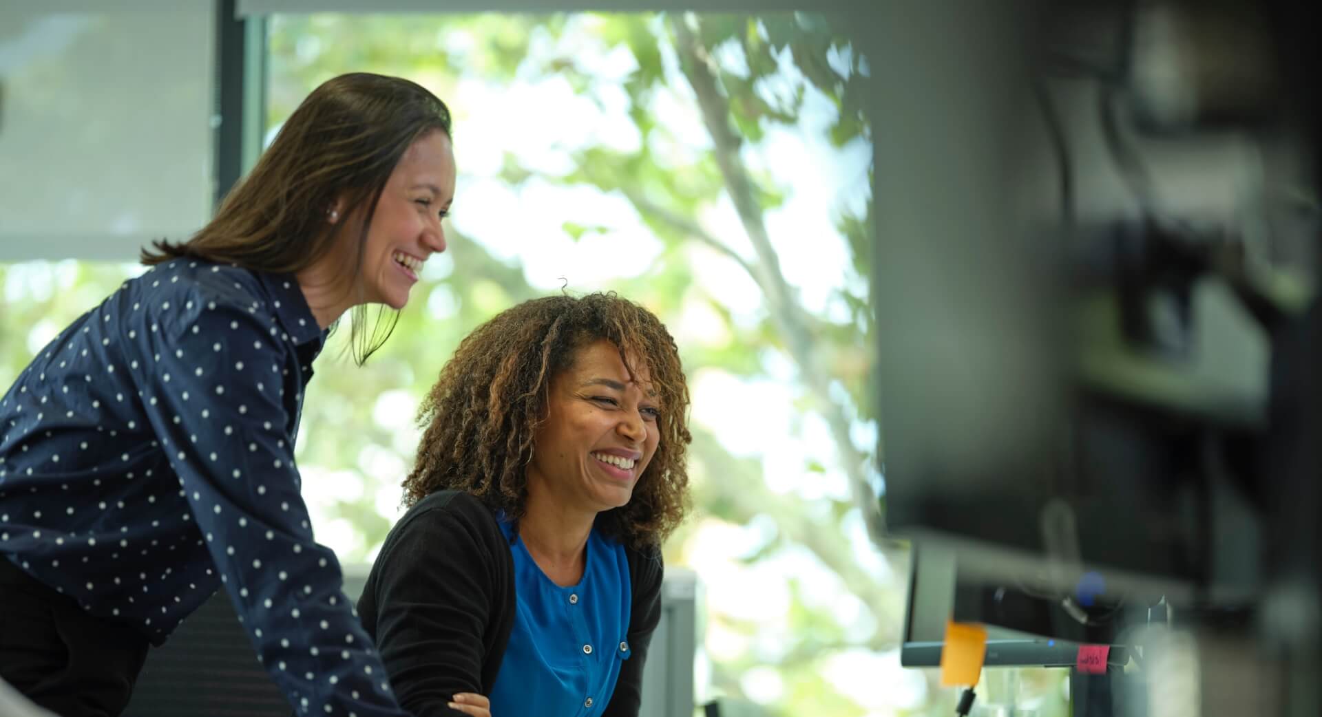 Two woman working looking at one computer screen together