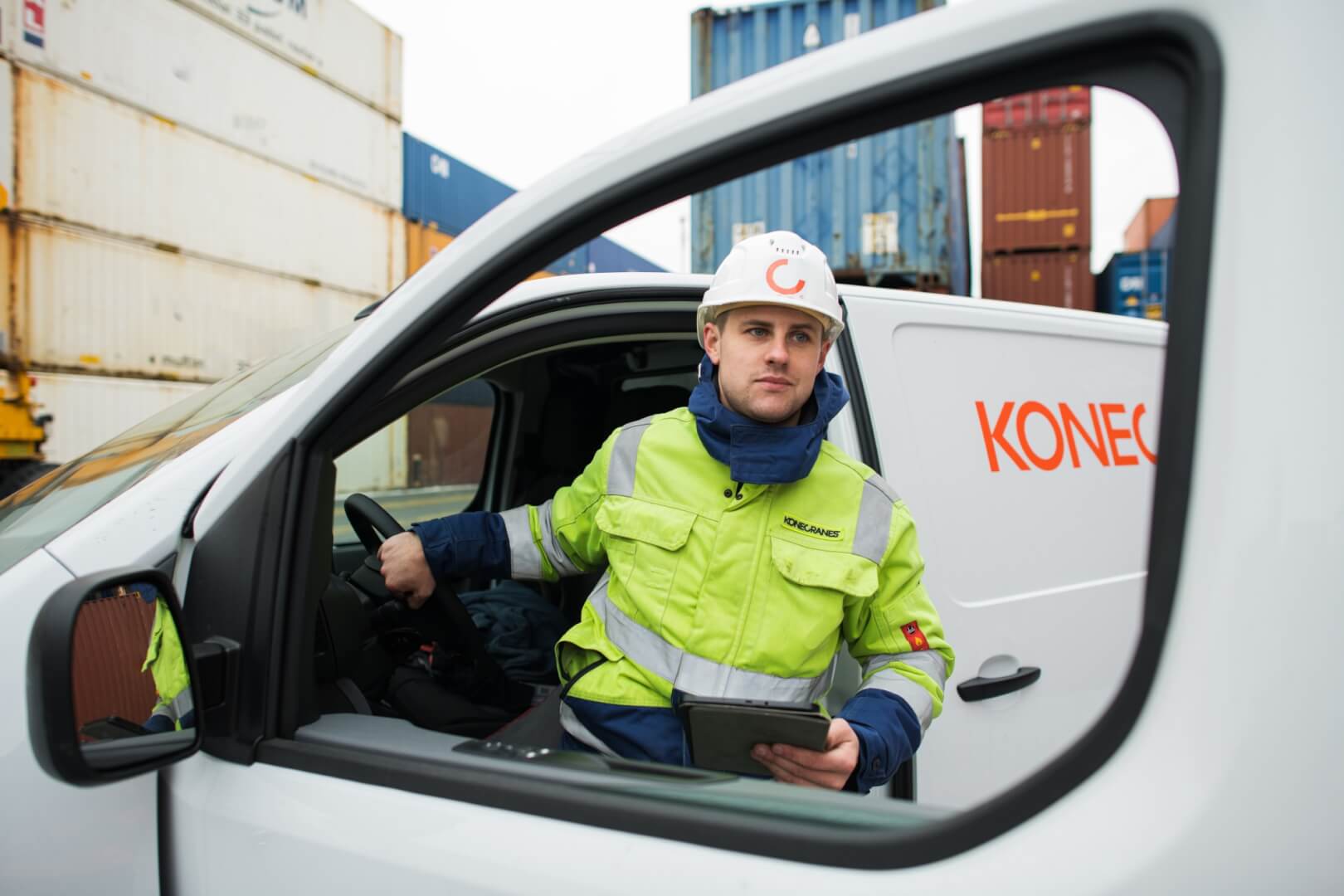 a man in high vis and a helment getting out of a white Koncranes branded van