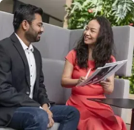 two people discussing documents with smiles on thier faces