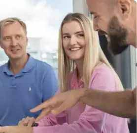 three people discussing documents with smiles on thier faces