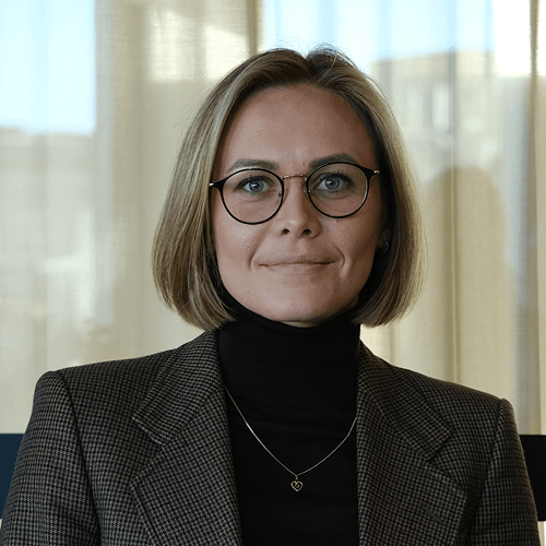 women sitting on a bed using a laptop