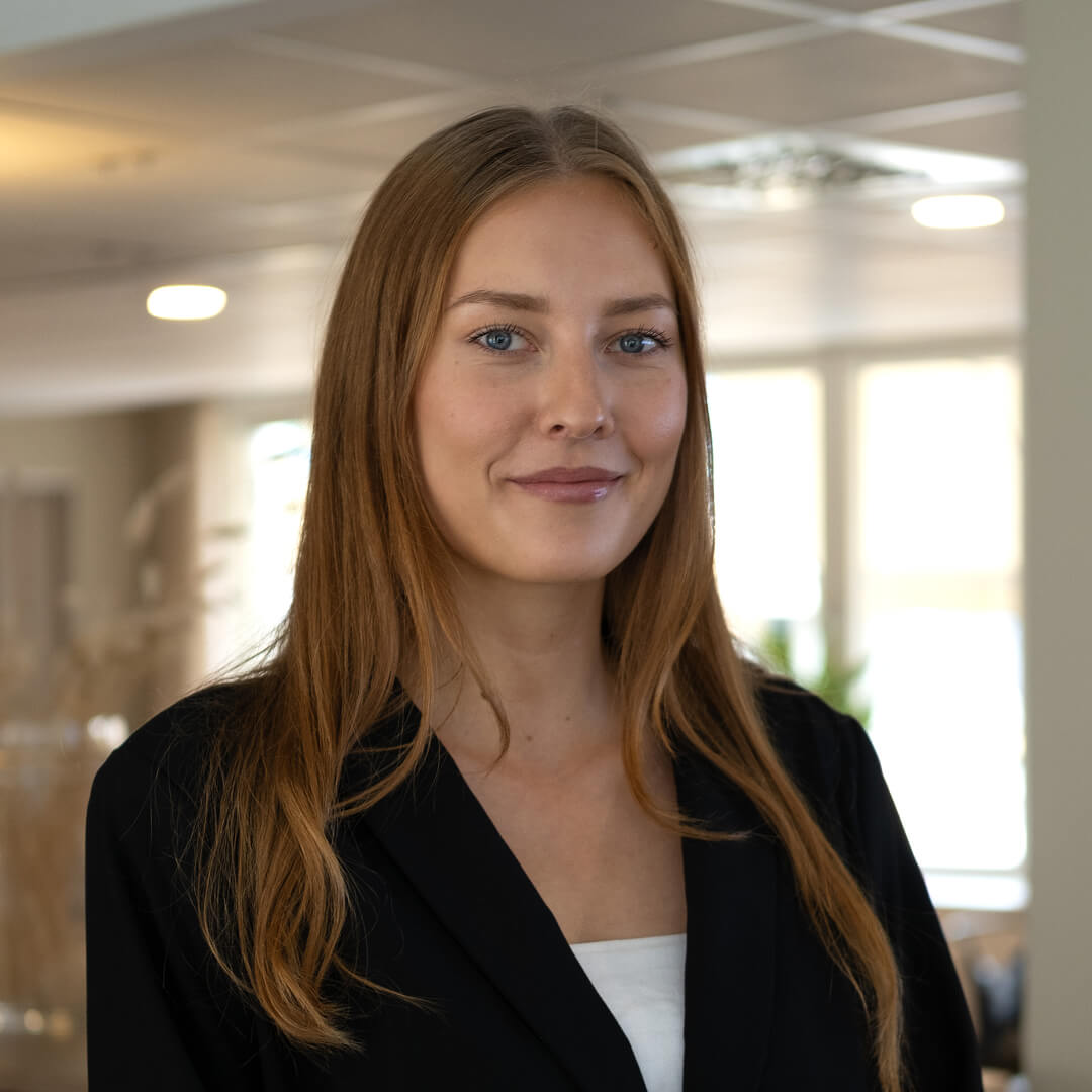 women sitting on a bed using a laptop
