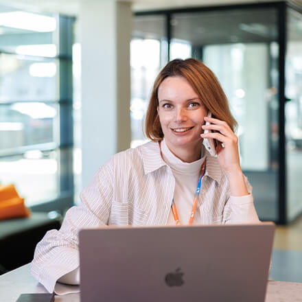 women sitting on a bed using a laptop