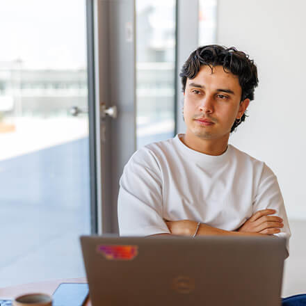 women sitting on a bed using a laptop
