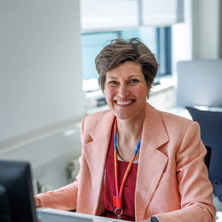 women sitting on a bed using a laptop