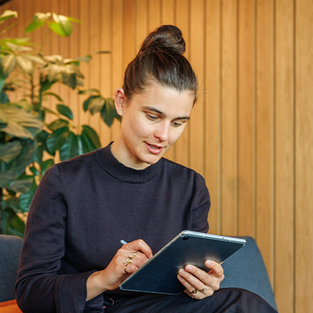 women sitting on a bed using a laptop
