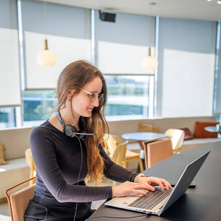 women sitting on a bed using a laptop