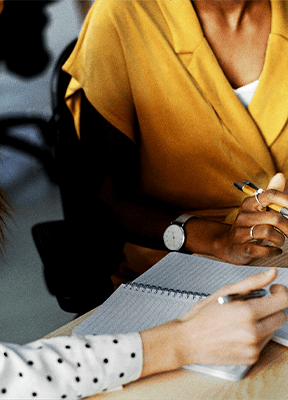 women sitting on a bed using a laptop