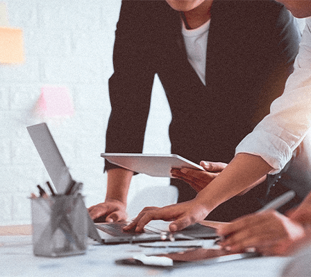 women sitting on a bed using a laptop