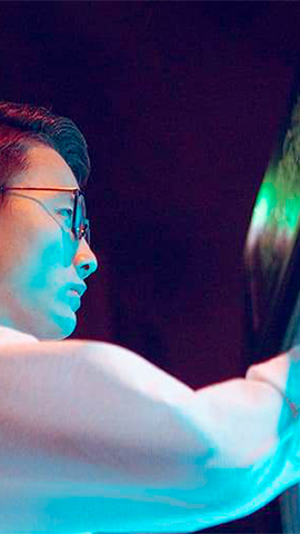 women sitting on a bed using a laptop