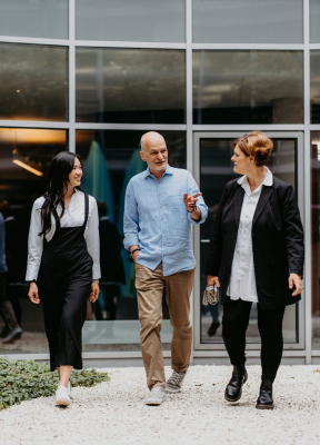 Three people walking in front of Sopra Steria's german offices