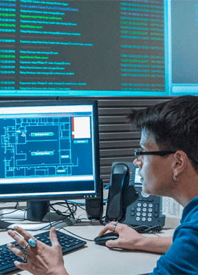 woman working in front of her computer and various screens displaying data