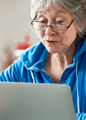 women sitting on a bed using a laptop