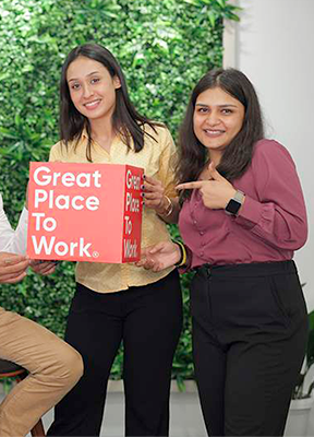 women sitting on a bed using a laptop