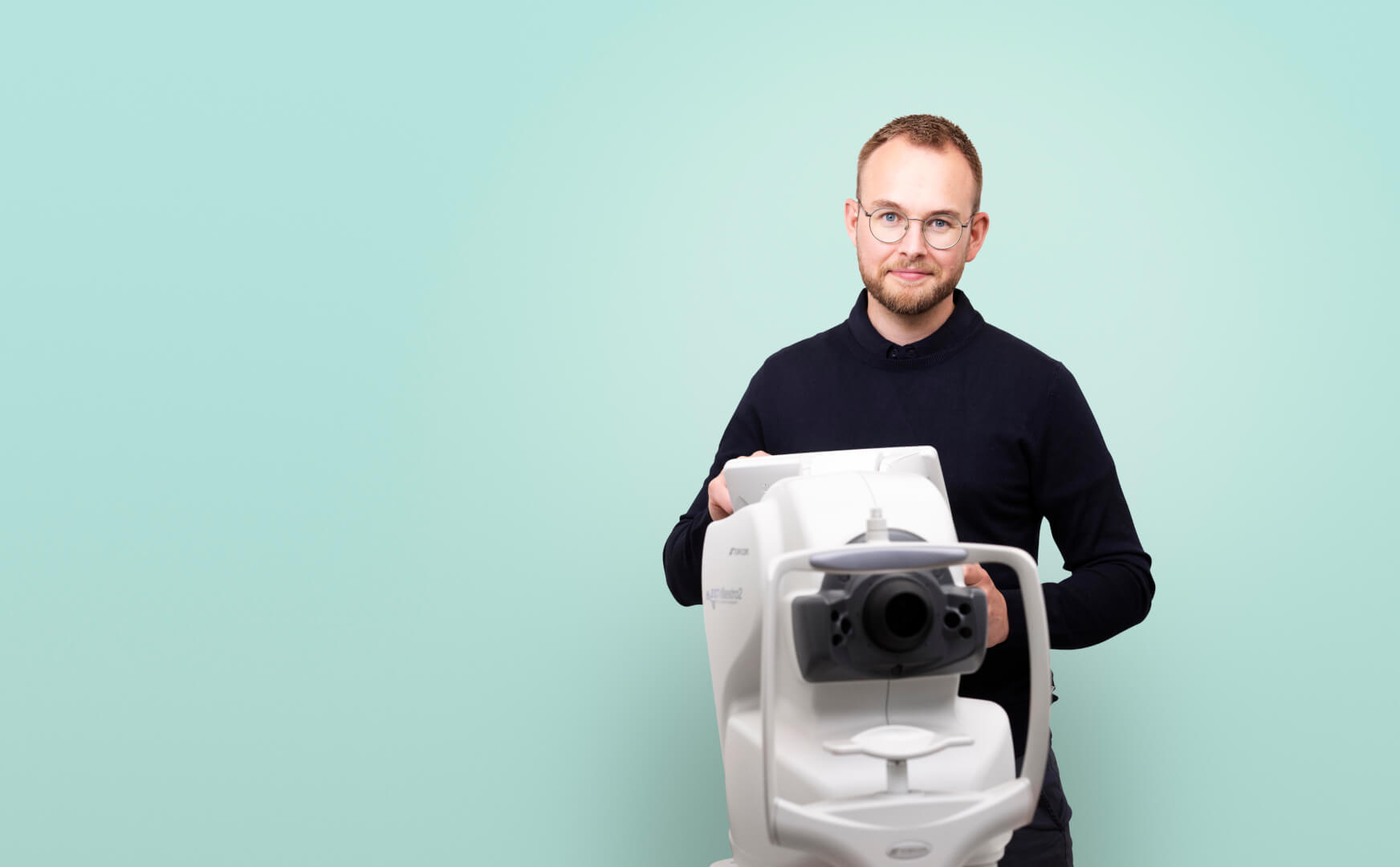 En optiker som ser gjennom teknisk utstyr
